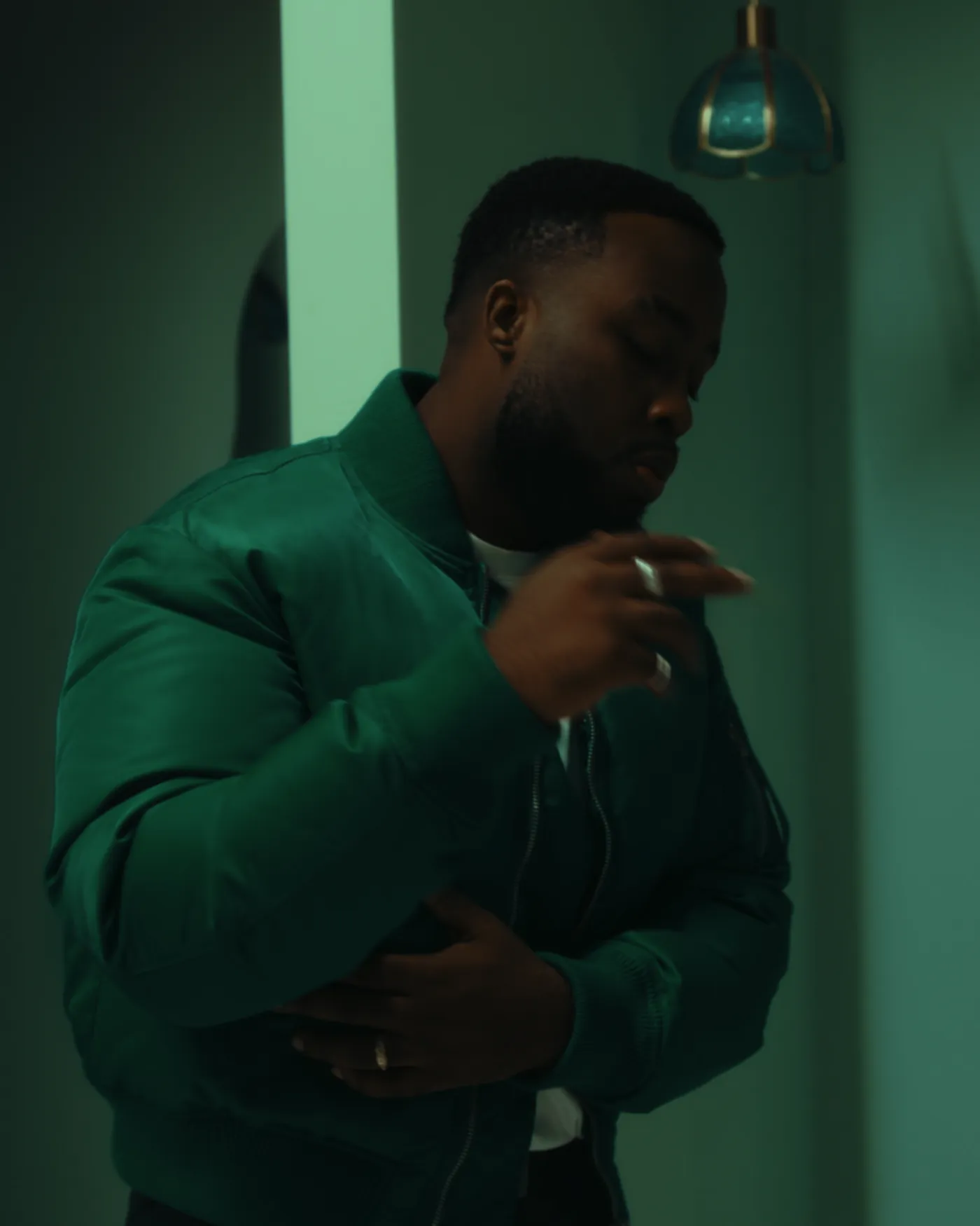 Artiste en veste verte, sous un éclairage vert